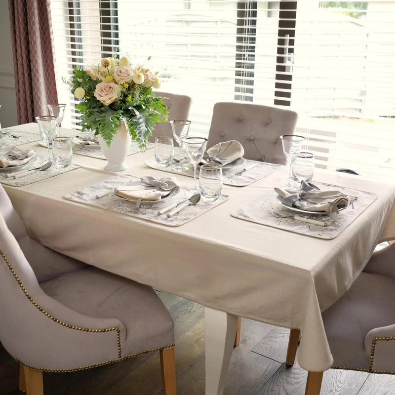 Double-sided cotton placemat set with gray twig embroidery and beige reverse with beige tablecloth.