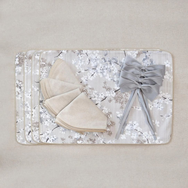 Double-sided cotton placemat set with gray twig embroidery and beige reverse with matching napkins and bows.