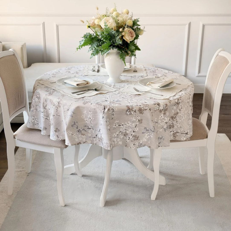 Double-sided cotton placemat set with gray twig embroidery and beige reverse on round table.