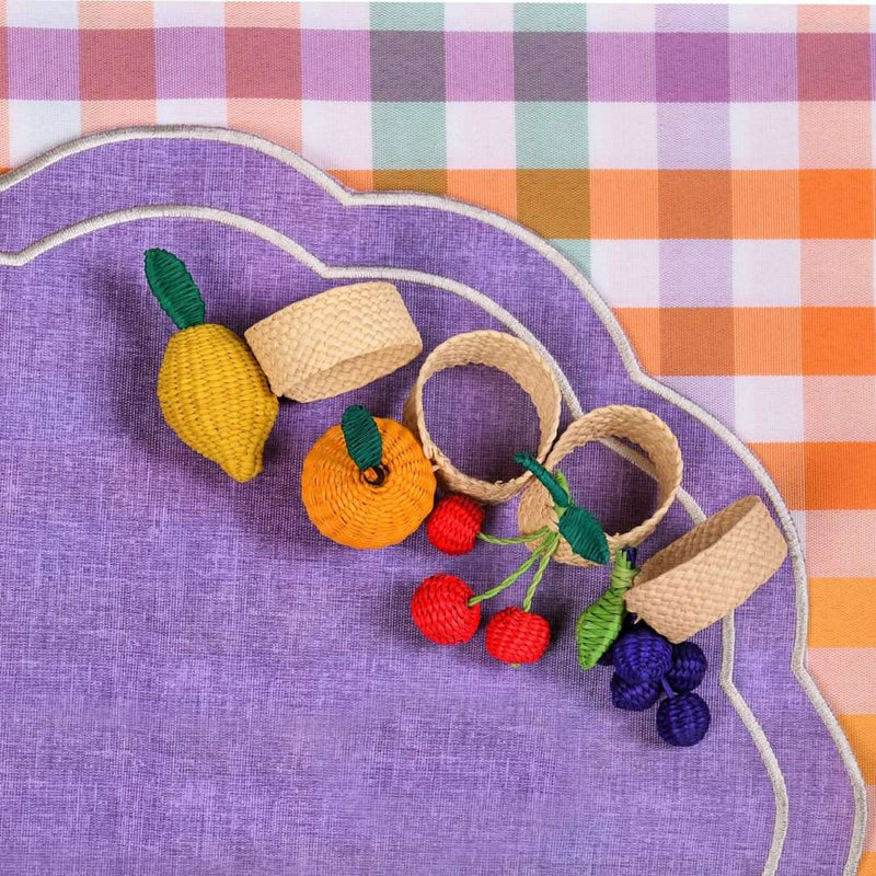 Rainbow Fruits napkin rings on a purple placemat by Roseberry Home