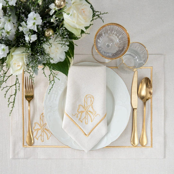 Light beige napkin with gold embroidered candy cane motif styled on plate.