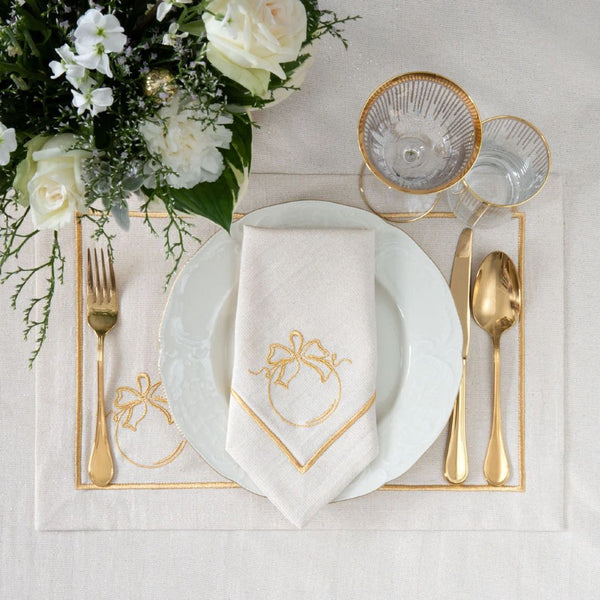 Light beige napkin with gold embroidered baubl motif styled on plate.