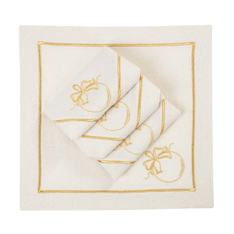 Folded light beige napkins with gold embroidered nauble motif on white background.