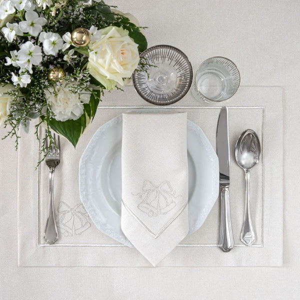 Silver lurex napkin with embroidered bell motif by Roseberry Home styled on plate.