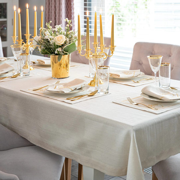 Light beige napkin with gold embroidered mistletoe motif styled on Christmas table setting.