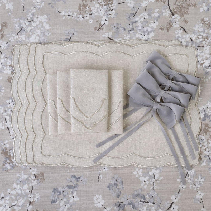 Silver embroidered cotton napkin by Roseberry Home presented next to silver velvet bows on an elegant table