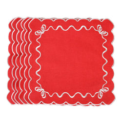 Unwrapped red cotton napkin with white embroidered festive bows in the corners.