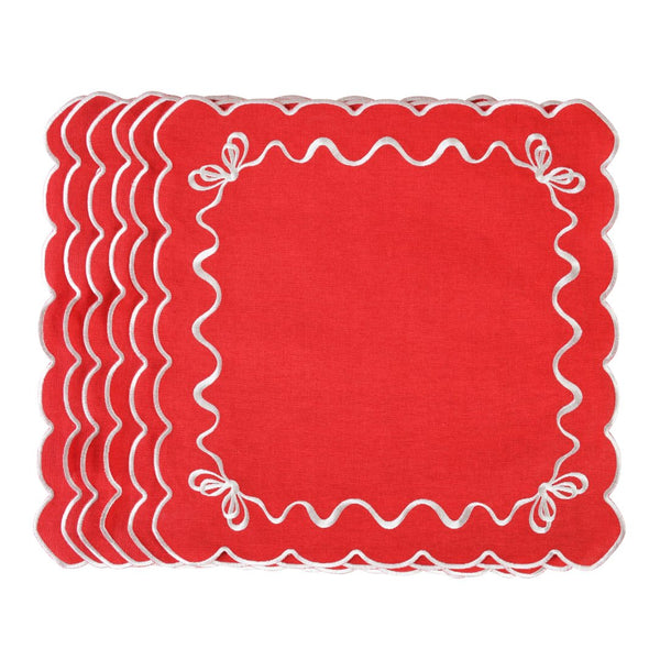 Unwrapped red cotton napkin with white embroidered festive bows in the corners.