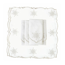 White cotton napkin with silver embroidered snowflakes details folded on white backgrouund.