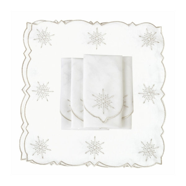 White cotton napkin with silver embroidered snowflakes details folded on white backgrouund.