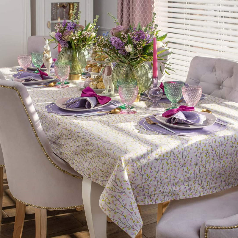 Purple Petali embroidered napkin with wave border on colourful table side view.