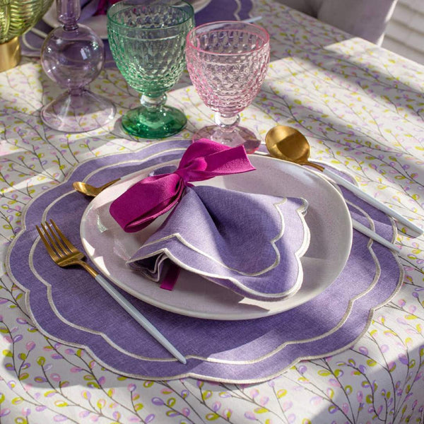 Purple Petali embroidered napkin with wave border on colourful table setting.