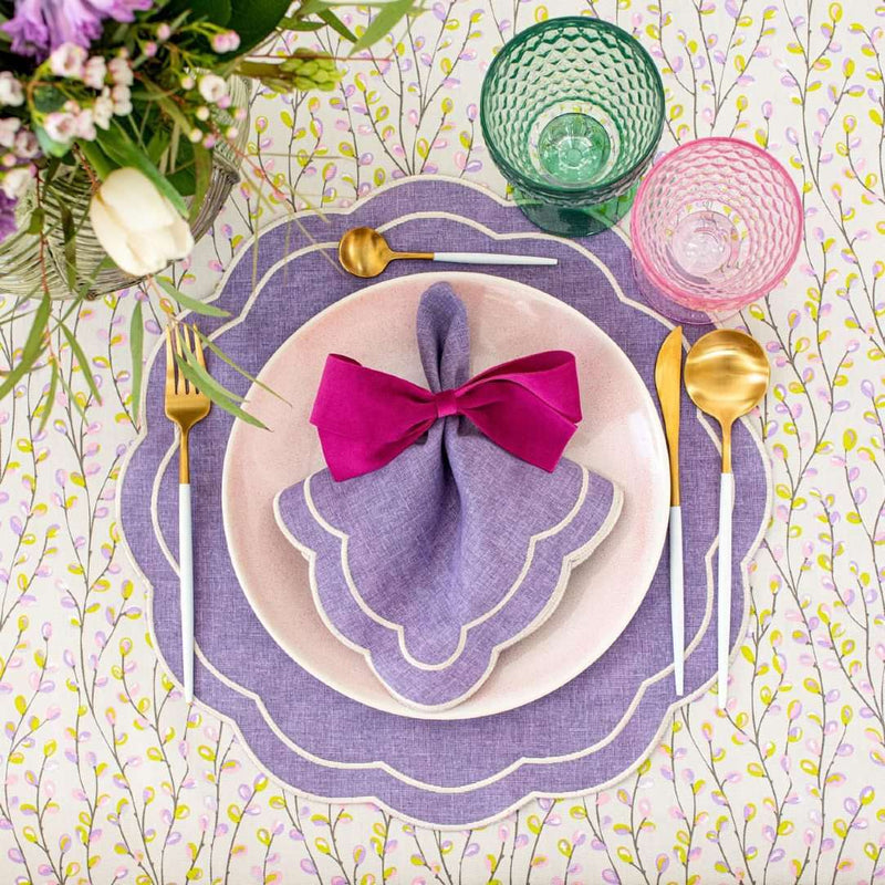 Purple Petali embroidered napkin with wave border styled with purple ribbon.