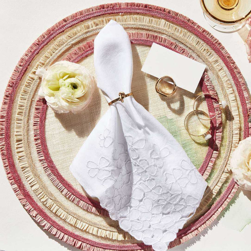 White linen napkin with embroidered hydrangea by Joanna Buchanan styled with rattan placemat