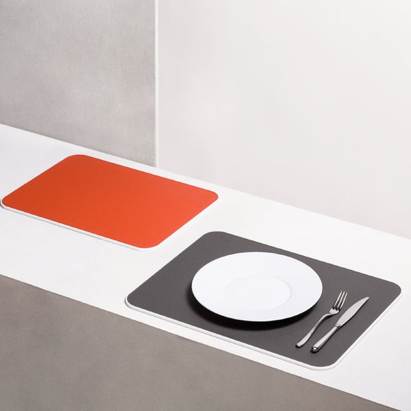 Rectangular Corian placemat with leather insert by Giobagnara styled on luxury setting.