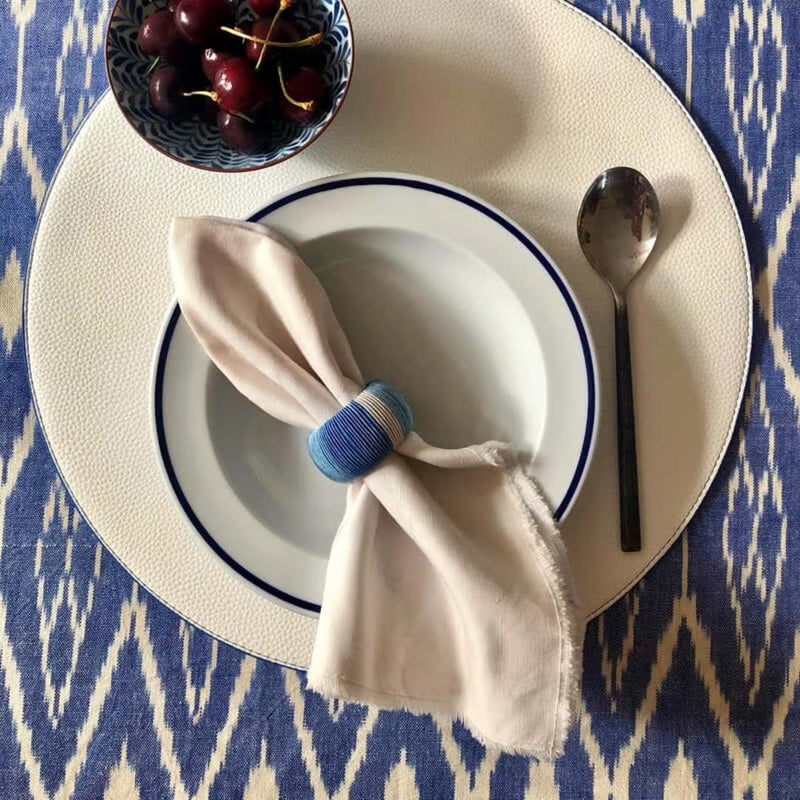 Reversible placemat in black and off-white faux leather styled white side.