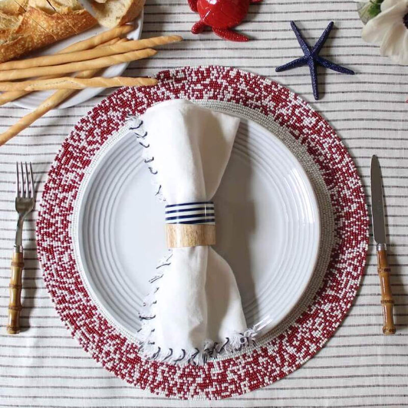 Von Gern Home Splatter placemat in red and white beads styled on coatal tablescape.