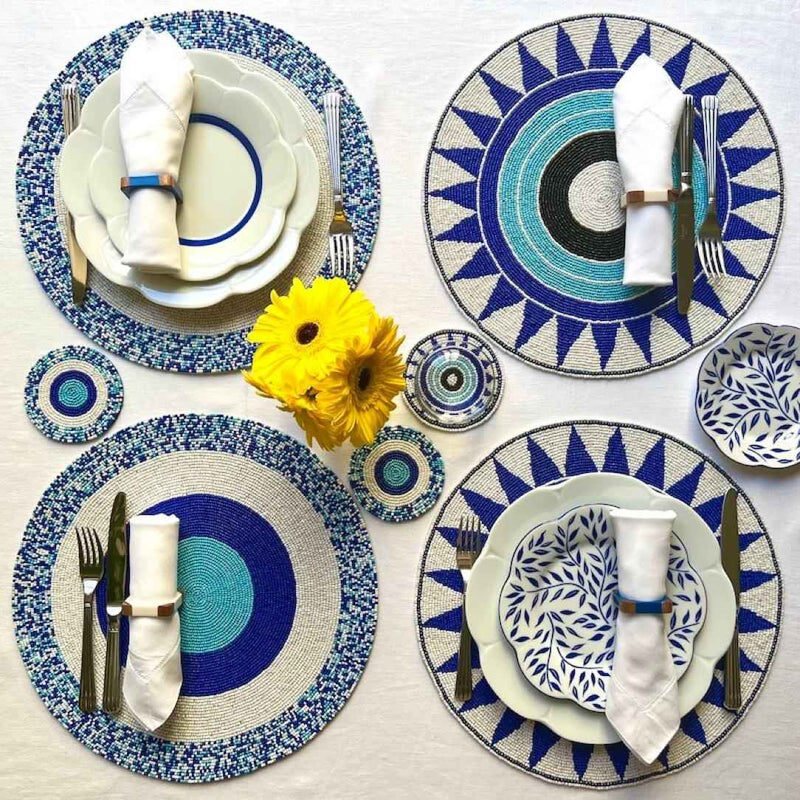 Blue hand-beaded placemat with geometric circle pattern with other matching placemats.
