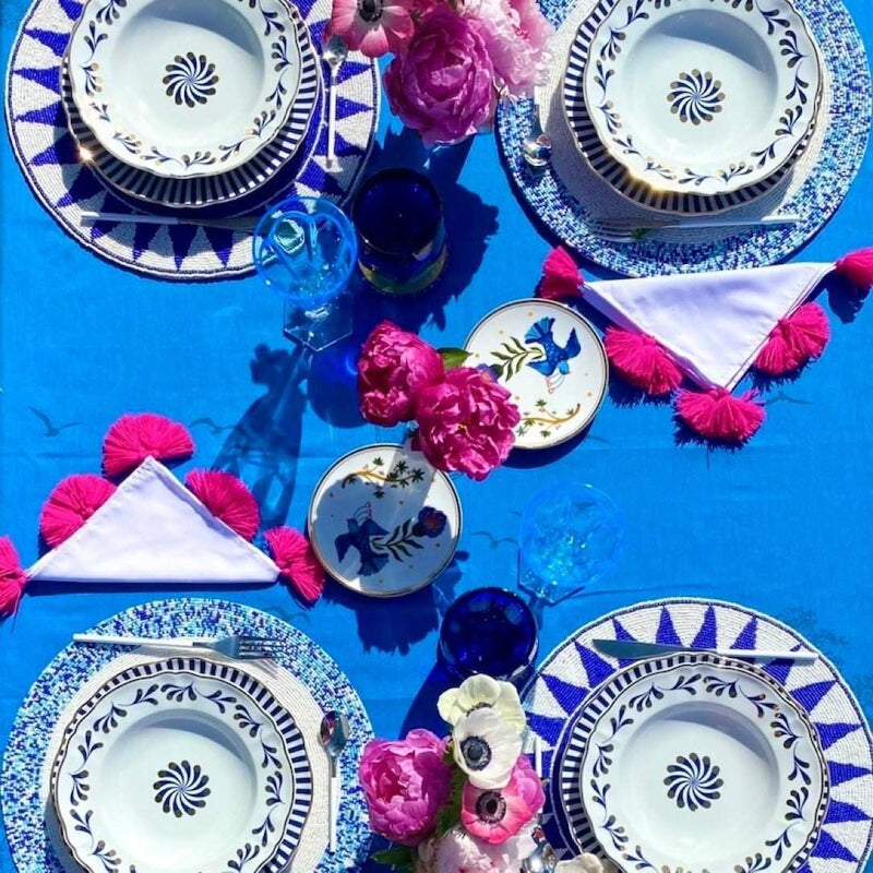 Blue hand-beaded placemat with tribal pattern on summer mediteranean tablescape.