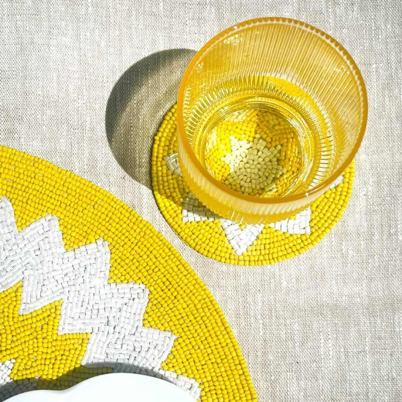 Capri placemat hand-beaded in yellow and white by Von Gern Home with matching coasters.