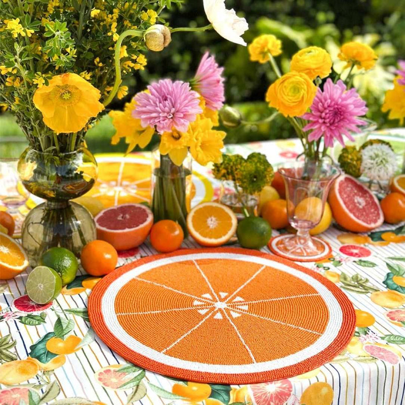Orange hand-beaded placemat by Von Gern Home on citrus summer tablescape.