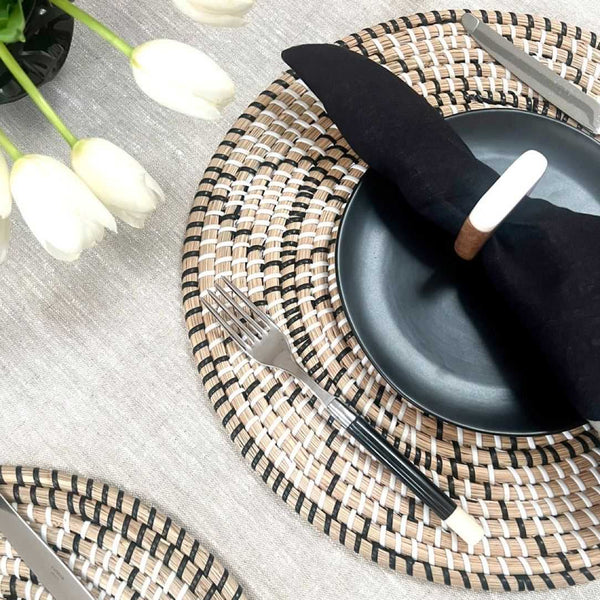 Terra woven placemat in seagrass styled with black napkin and white napkin ring side view.