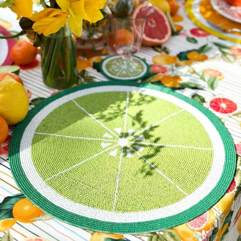 Lime green hand-beaded placemat, citrus-inspired by Kim Seybert on summer table setting.