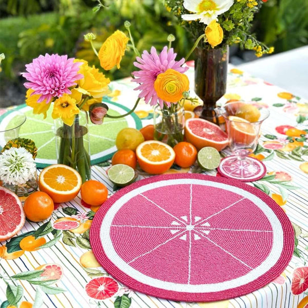 Grapefruit hand-beaded placemat in reddish-pink by Von Gern Home on summer tablecape.