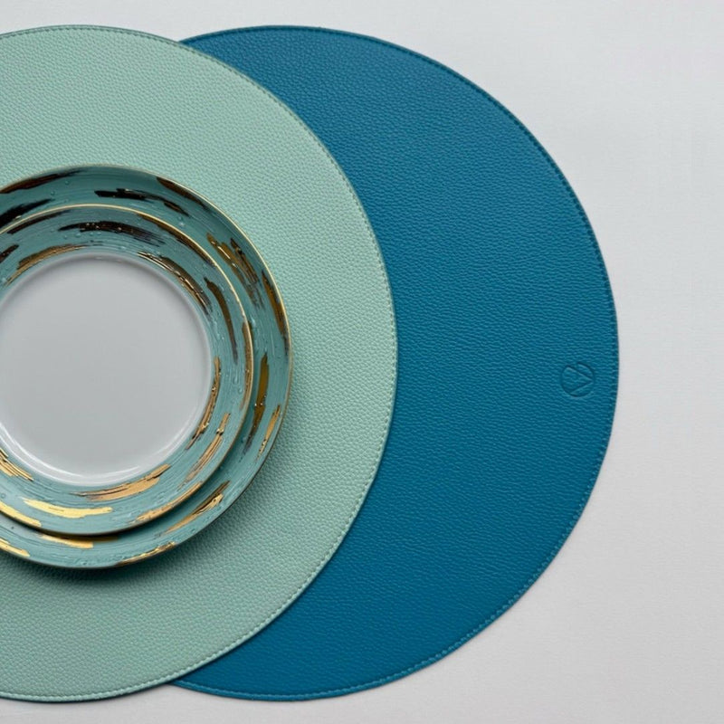 Reversible placemat in sky blue and light blue faux leather styled.