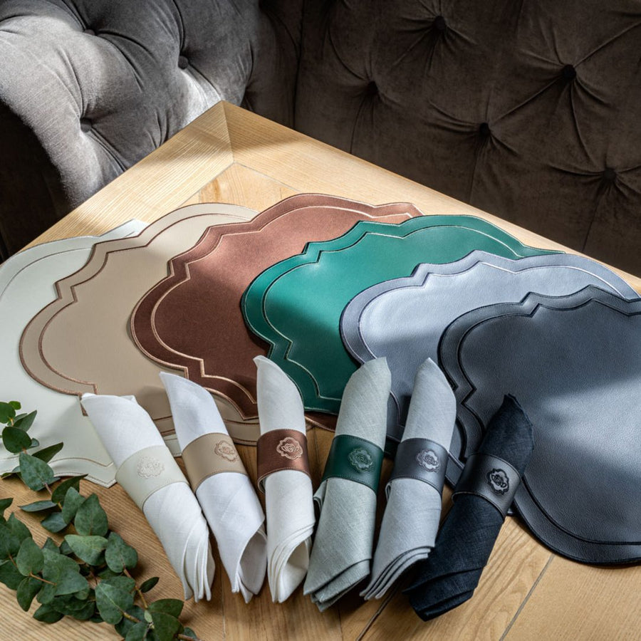 Heritage placemats displayed in a range of colours, showing the scalloped silhouette in premium faux leather.