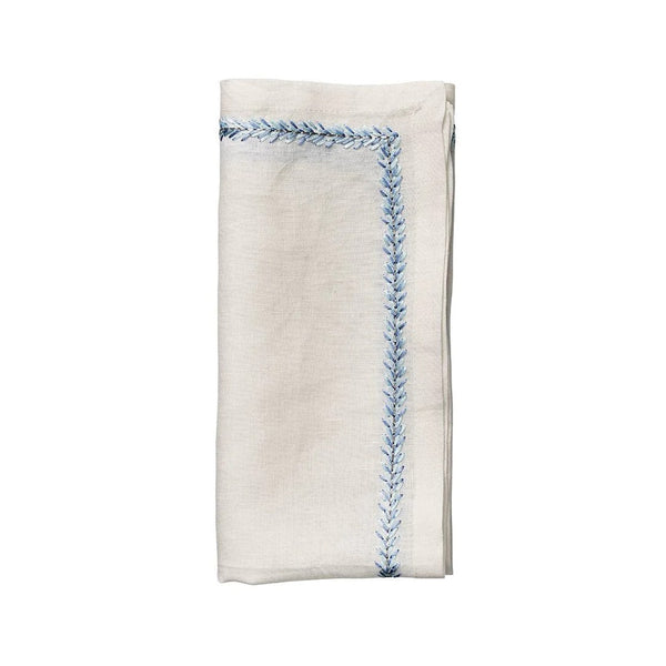 White linen napkin with periwinkle embroidered border by Kim Seybert on white background, sold by Amiramour