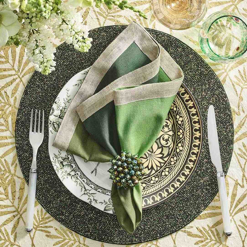 Luxurious table arrangement in rich green tones with Zinnia Napkin Rings by Kim Seybert