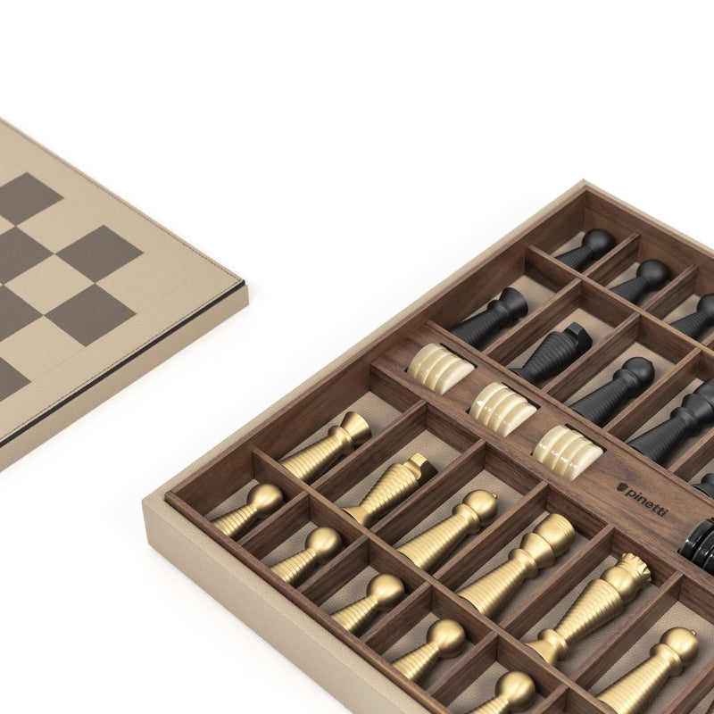 Detail of Pinetti chess and checkers board featuring walnut compartments and handcrafted chess pieces in black and brass finish.