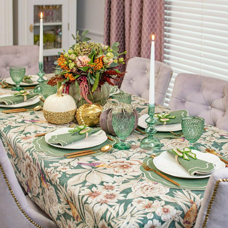 Green and beige bow napkin ringsby Roseberry Home styled next to decorative pumpkins.