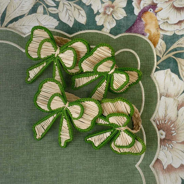 Green and beige bow napkin ringsby Roseberry Home styled on matching tablecloth.
