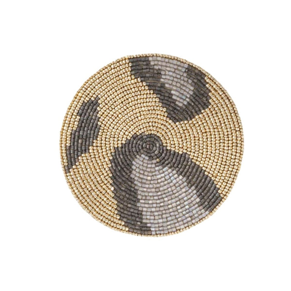 Round beaded coaster with gold and black pattern on a white background