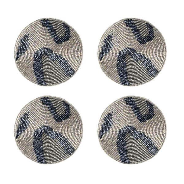 Four round beaded coasters with blue and silver patterns on a white background