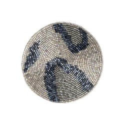 Round beaded coaster with blue and silver pattern on a white background