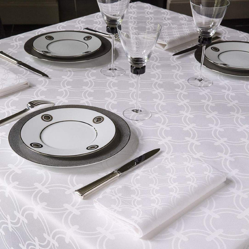 Table set with white tablecloth, plates and glasses