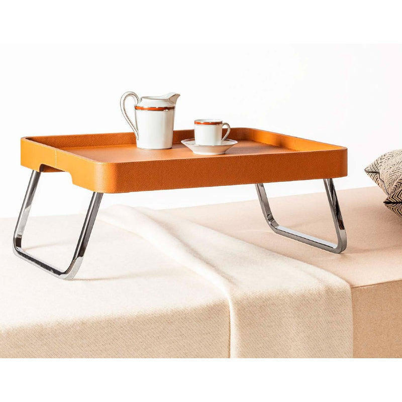 Bed Leather Folding Tray in SC 66 India Pelle Frau® by Giobagnara x Poltrona Frau with a white teapot and cup on a beige surface