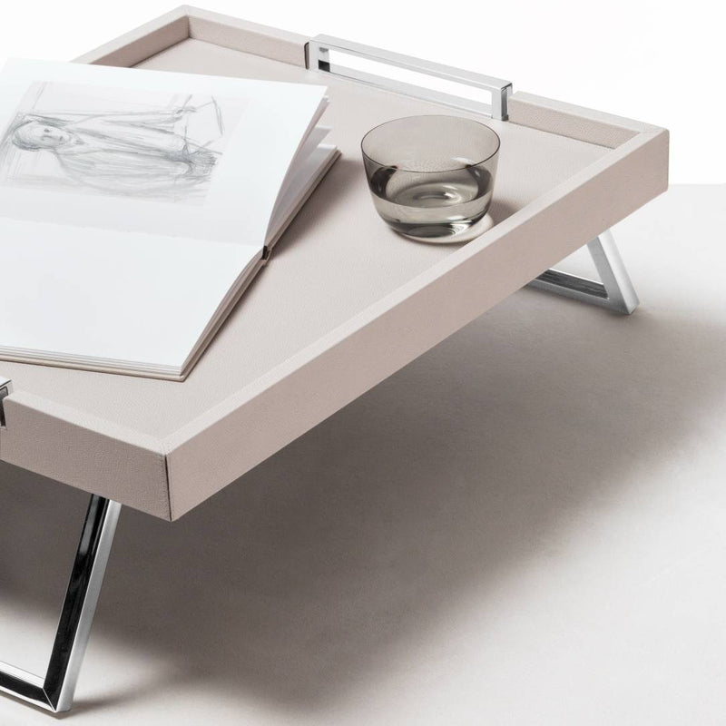 Bed Leather Folding Tray Vic by Giobagnara with a glass bowl and open book on a white surface