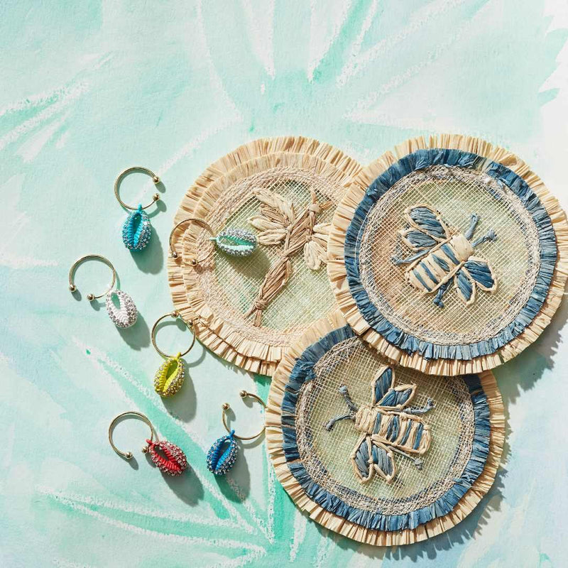Decorative coasters with embroidered designs on a textured light blue background