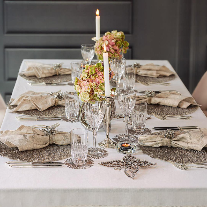 Elegant table setting with floral centerpieces, candles, and decorative napkins.