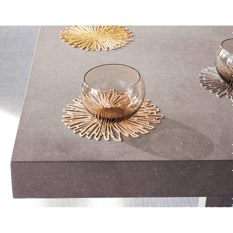 Glass bowl on a decorative gold coaster on a gray surface