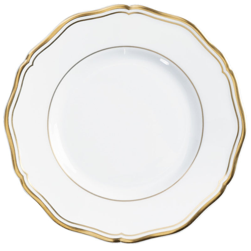 A round, white porcelain bread and butter plate with gold accents and a gold rim.