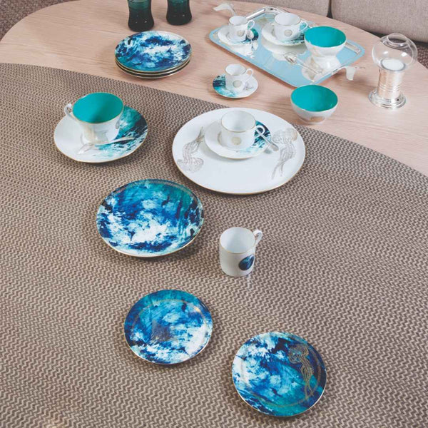 Ceramic tableware set with blue and white designs on a textured surface