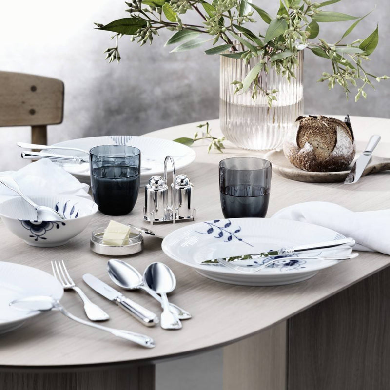 Dining table set with floral-patterned plates, silverware, and a Silver-plated butter dish with crystal base by Robbe & Berking 
