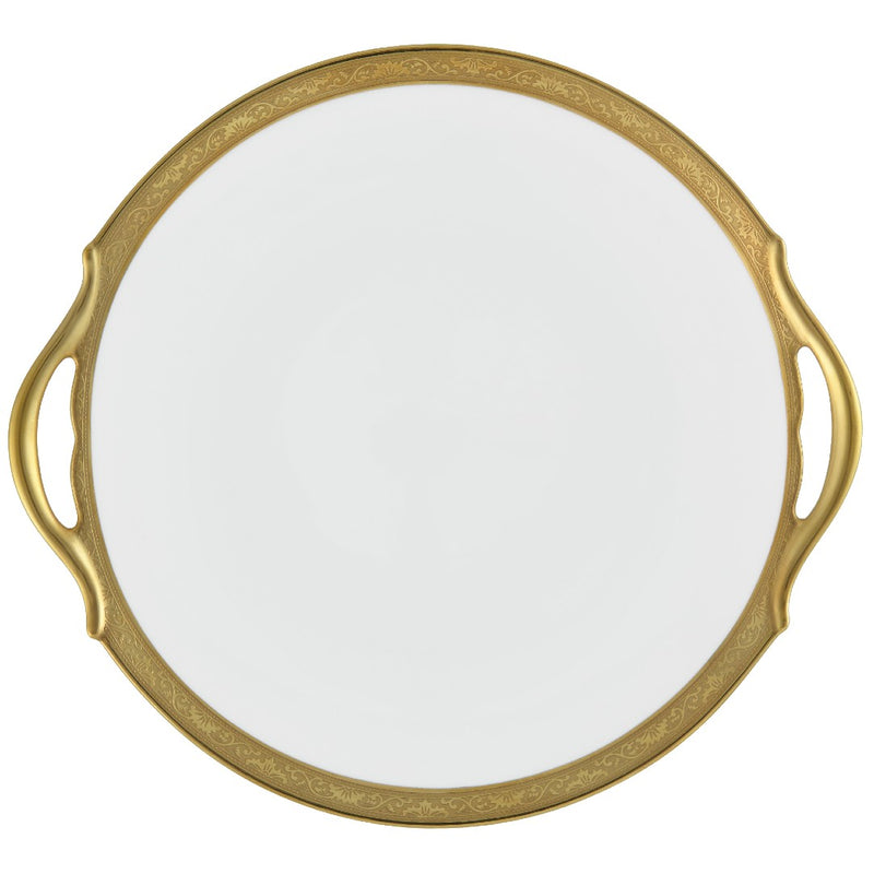 A white porcelain cake dish with a gold Renaissance style border, inlaid with gold details, and a handle on the side.