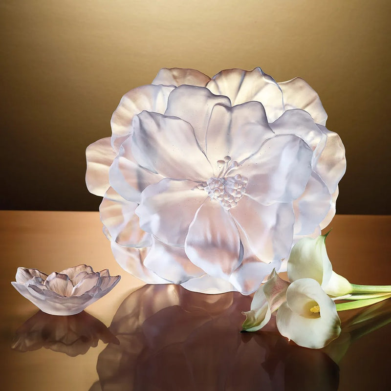 Floral-shaped crystal decor with a soft glow on a reflective surface