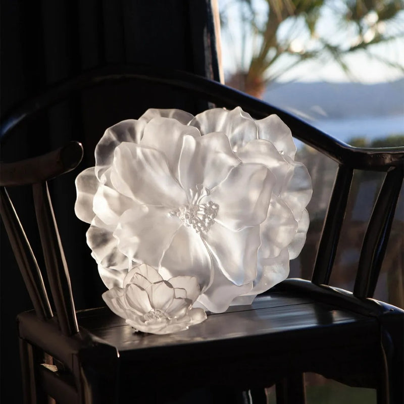 White floral crystal decor on a dark wooden chair with a blurred outdoor background